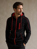 Man draagt een zwarte fleece hoodie met rode details en volledige rits, driekwartaanzicht
