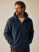Man in marineblauwe fleece jas met capuchon, driekwart aanzicht