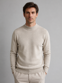 Man draagt beige gebreide trui met lage col, voorkant