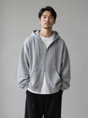 Man draagt grijze oversized zip hoodie met capuchon, voorkant