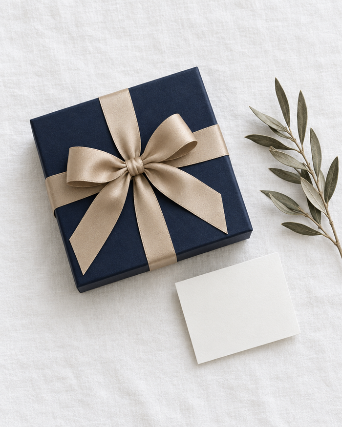 Navy gift box with a sand-colored ribbon